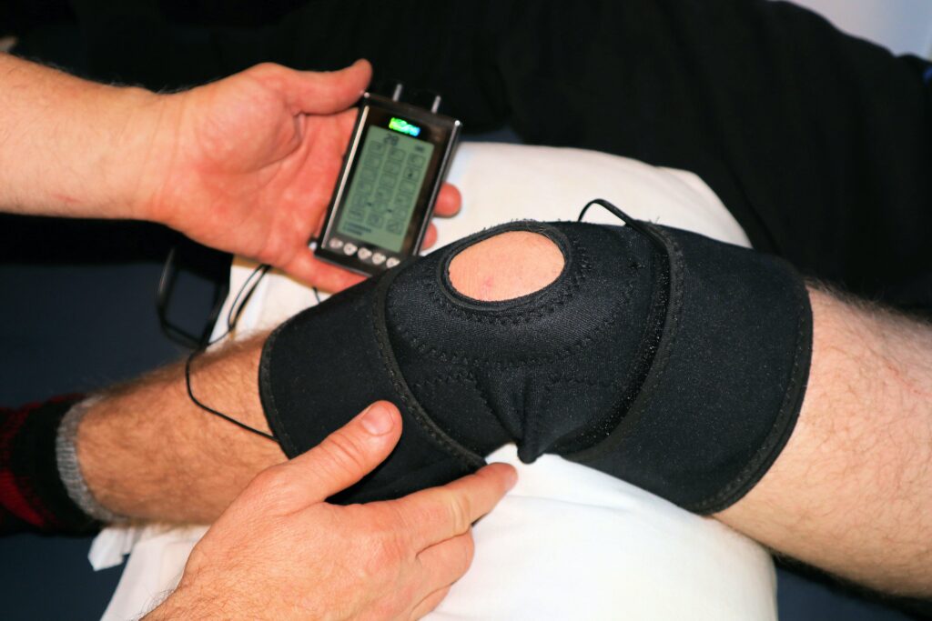 Elektrotherapie bei Schmerzen: Das Bild zeigt, wie ein Knie mit Elektrotherapie behandlet wird